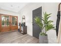 Bright foyer featuring hardwood floors, a wooden front door, stylish furniture, and a modern plant at 4605 Western Union School Rd, Waxhaw, NC 28173