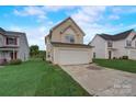 Two-story house with a beige exterior, attached garage, and a well-maintained lawn at 5813 Bridgeway Dr, Indian Trail, NC 28079