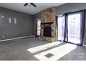 Living room with stone fireplace and sliding glass doors leading to a patio at 7912 Charter Oak Ln, Charlotte, NC 28226