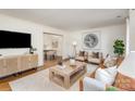 Bright living room featuring a stylish decor with light-colored furniture, a modern TV stand and hardwood floors at 821 Greentree Dr, Charlotte, NC 28211