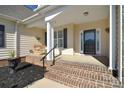 Inviting front porch with a swing, classic columns, and brick steps at 102 W Vista View Pl, Mooresville, NC 28117