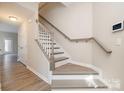 Inviting foyer showcasing staircase with gray trim and wood-style floors, creating a warm welcome at 12584 Jessica Pl, Charlotte, NC 28269