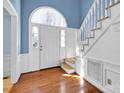 Bright entryway with hardwood floors, staircase, and an arched window at 12822 Angel Oak Dr, Huntersville, NC 28078