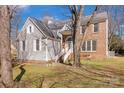 Two-story house with gray siding and brick accents, featuring a landscaped yard at 12822 Angel Oak Dr, Huntersville, NC 28078