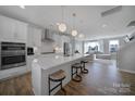 Bright kitchen features stainless steel appliances, white cabinetry and an island with bar seating at 14139 Loyola Ridge Dr, Charlotte, NC 28277