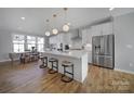 Open kitchen boasts an island with bar seating, stainless steel appliances and white cabinetry at 14139 Loyola Ridge Dr, Charlotte, NC 28277