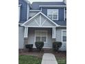 Gray siding townhome with a charming front porch and brick accents at 14955 Alexander Place Dr, Huntersville, NC 28078