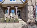 Inviting front porch with seating, decorative columns, and a beautifully adorned front door at 2001 Arbor Hills Dr, Indian Trail, NC 28079