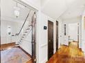 Bright foyer with hardwood floors, a staircase, and elegant lighting fixtures at 2315 Red Fox Trl, Charlotte, NC 28211