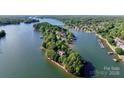 Aerial view of a luxury lakefront home surrounded by lush greenery and serene blue waters at 296 Windemere Isle Rd, Statesville, NC 28677