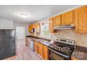 Functional kitchen features oak cabinets, modern appliances, and laminated countertops at 3138 Morson St, Charlotte, NC 28208