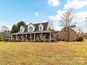 Charming brick home featuring a long, inviting porch, and a well-maintained front yard at 3300 Chancellor Ln, Monroe, NC 28110