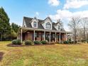 Charming brick home featuring a long, inviting porch, and a well-maintained front yard at 3300 Chancellor Ln, Monroe, NC 28110