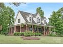 Beautiful brick home features a large porch with greenery, creating a warm and inviting entrance at 3300 Chancellor Ln, Monroe, NC 28110