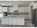 Bright white kitchen with stainless steel appliances, large island, and stylish backsplash at 4122 Eastover Glen Rd # 0316, Charlotte, NC 28269
