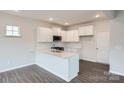 Bright eat-in kitchen with white cabinets, stainless sink, and modern appliances at 5725 Olive Beach Rd, Kannapolis, NC 28081