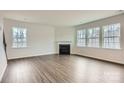 Living room with wood floors, fireplace, and multiple bright windows at 5725 Olive Beach Rd, Kannapolis, NC 28081