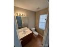 Neutral-toned powder room with a window for natural light and classic fixtures at 5956 Prescott Ct, Charlotte, NC 28269