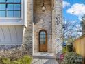 Elegant arched front door with sidelights, brick entryway, and landscaping at 633 Mattie Rose Ln, Charlotte, NC 28204