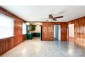 Open concept view of living room with wood paneling leading into the kitchen with green cabinets at 6523 Prospect Rd, Monroe, NC 28112