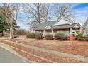 Quaint white house with a wrap-around porch and red brick accents at 830 Lowder St, Albemarle, NC 28001