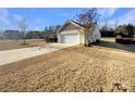 View of the two-car garage with driveway and yard at 934 Pointe Andrews Dr, Concord, NC 28025