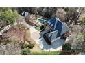 Expansive aerial view of home with a pool, lush greenery, circular drive and three-car garage at 14407 Brick Church Ct, Charlotte, NC 28277