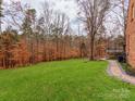 Spacious green backyard with a brick walkway to the side of the home at 25 Blenheim Ne Ct, Concord, NC 28025