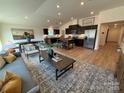 Spacious living room flows into kitchen with stainless steel appliances and a center island at 326 Knotty Wood Dr # 66, Monroe, NC 28110