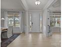 Bright and airy entryway with a white door, hardwood floors, and transom windows at 5024 Hillshire Ln, Mint Hill, NC 28227
