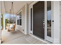 Close-up of the front door with a swing on the porch, enhancing curb appeal at 5024 Hillshire Ln, Mint Hill, NC 28227