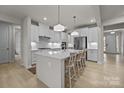 Modern kitchen featuring white cabinets, a spacious island with seating, and pendant lighting at 5024 Hillshire Ln, Mint Hill, NC 28227