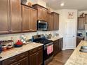 Well-appointed kitchen featuring granite countertops, stainless steel appliances, and dark wood cabinets at 8906 Powder Works Dr, Huntersville, NC 28078