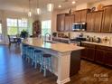 Spacious kitchen featuring a large granite island with seating, stainless steel appliances, and ample storage at 8906 Powder Works Dr, Huntersville, NC 28078