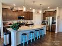 Modern kitchen with a spacious granite island, stainless steel appliances, and beautiful dark wood cabinets at 8906 Powder Works Dr, Huntersville, NC 28078