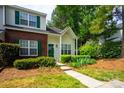Lovely townhome featuring a blend of brick and siding, enhanced by verdant foliage and eye-catching green shutters at 1748 Pergola Pl, Charlotte, NC 28213