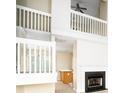 Bright living room featuring a cozy fireplace, high ceilings, and open staircase at 1748 Pergola Pl, Charlotte, NC 28213