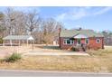 Charming red brick home featuring a covered carport and a well-maintained front yard at 1902 Old Wilkesboro Rd, Statesville, NC 28625