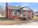 Charming brick home featuring a black awning, chimney, and landscaped garden under a blue sky at 1902 Old Wilkesboro Rd, Statesville, NC 28625