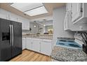 Bright kitchen featuring white cabinets, granite countertops, and modern black appliances for contemporary design at 2745 Tiergarten Ln, Charlotte, NC 28210