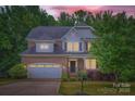 Charming two-story home with a brick facade, attached garage, and well-manicured front yard at dusk at 2864 Park Ridge Blvd, Rock Hill, SC 29732