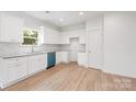Well-lit kitchen featuring sleek white cabinets, granite countertops, and modern stainless steel appliances including a blue dishwasher at 406 Killian Ave, Mount Holly, NC 28120