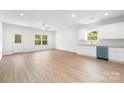 Open concept living area and kitchen with bright natural light, wood floors, and modern white cabinetry at 406 Killian Ave, Mount Holly, NC 28120