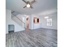 Open-concept living area features modern gray flooring, white walls, and a staircase, creating a bright and airy space at 502 Geneva Cir, Gastonia, NC 28056