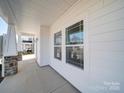 Inviting covered porch featuring stone-based white pillars and large windows, offering curb appeal and natural light at 502 Geneva Cir, Gastonia, NC 28056