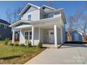 Charming two-story home featuring a covered front porch and separate storage shed at 554 Geneva Cir, Gastonia, NC 28056