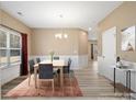 Bright dining room featuring wood-look floors, modern chandelier, and a table set for six at 6351 Trinity Crossing Cir, Kannapolis, NC 28081