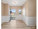 Bright entryway with white wainscoting, hardwood floors, and access to other rooms at 6351 Trinity Crossing Cir, Kannapolis, NC 28081