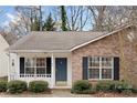 Close-up of brick home featuring a stylish blue front door, white trim, and neat landscaping with evergreen bushes at 1109 Cherry Meadow Ln, Rock Hill, SC 29732