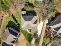 Overhead shot of a brick home's backyard, green lawn, trees, patio, and neighboring houses at 11402 Bloomfield Dr, Charlotte, NC 28277